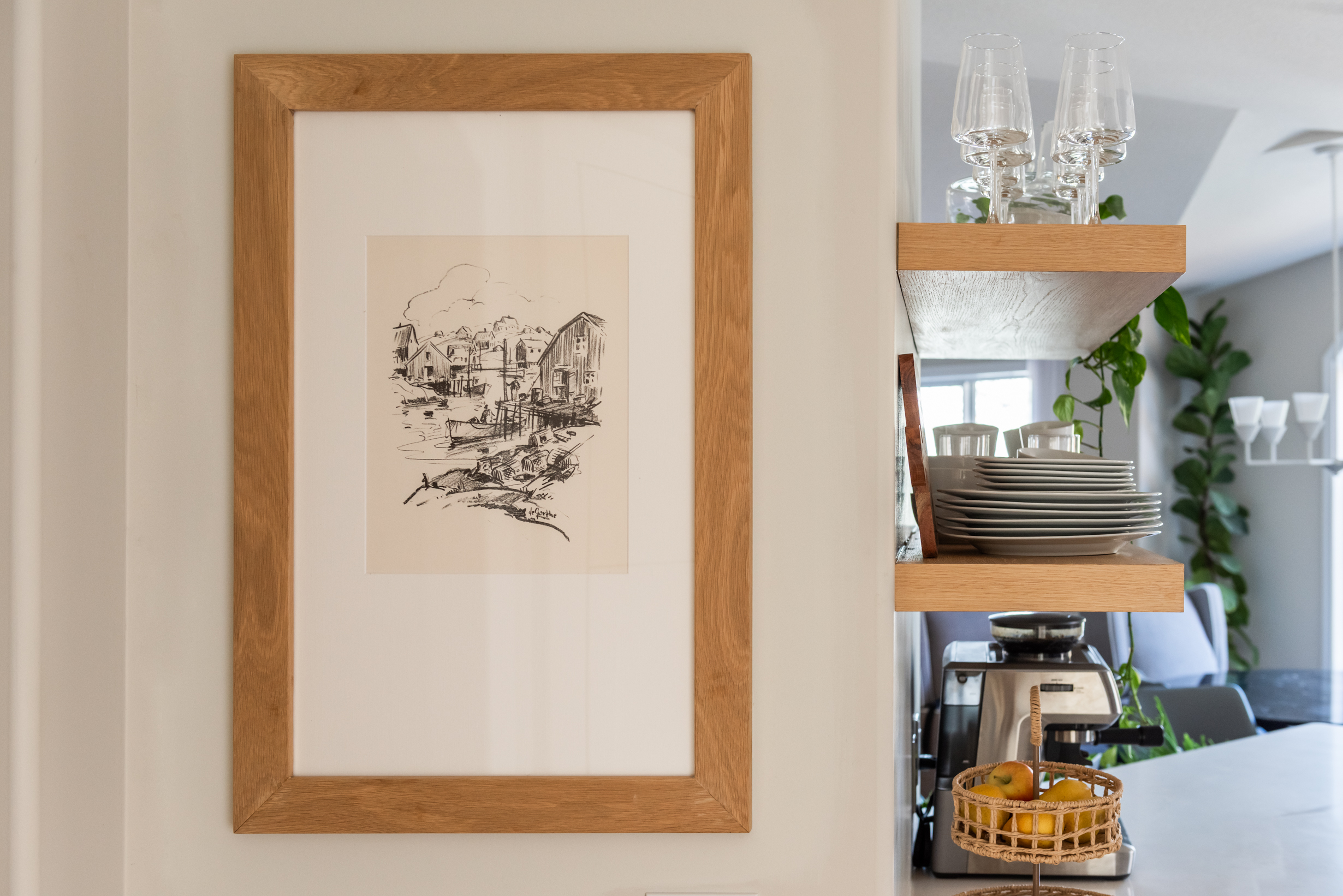 Kitchen wall detail showing flush framed art panel that opens to reveal concealed storage behind.