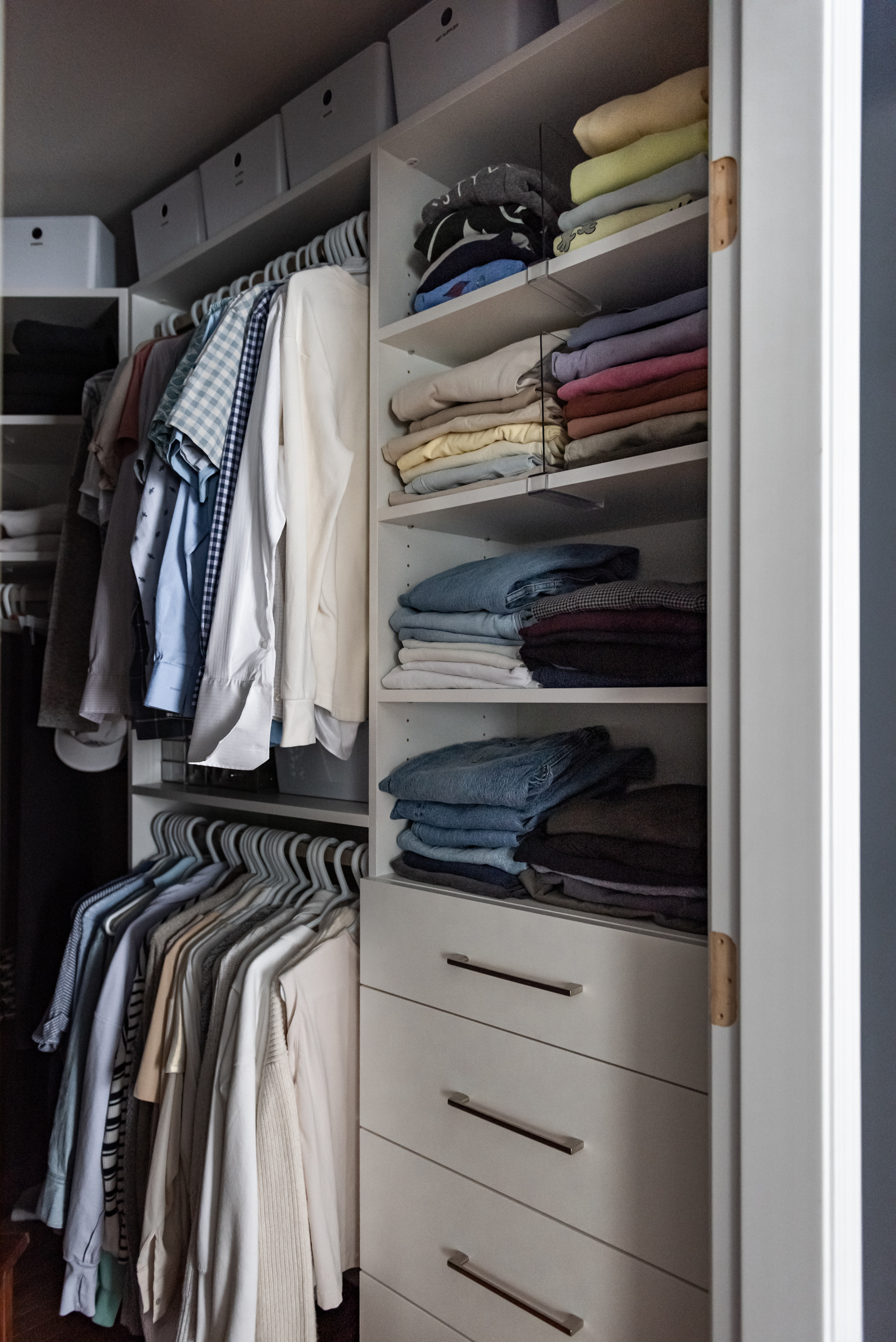 Custom walk in closet with built in storage zones for hanging clothes, folded items, and accessories.