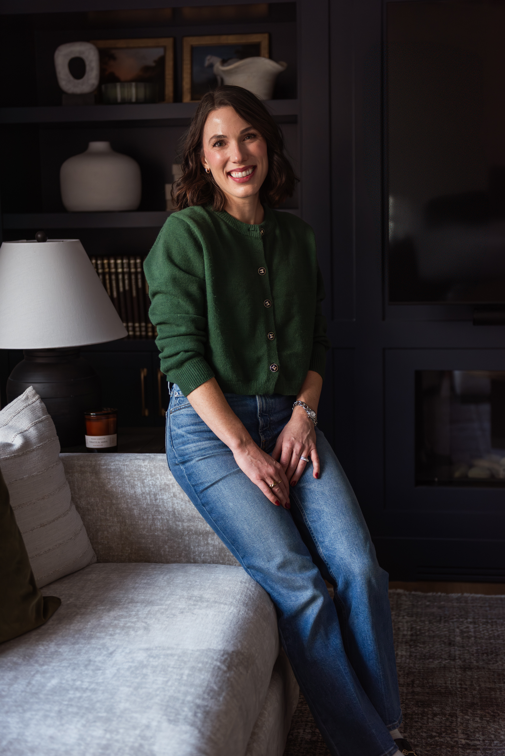 Woman in modern living room with linear fireplace and custom built-in cabinetry