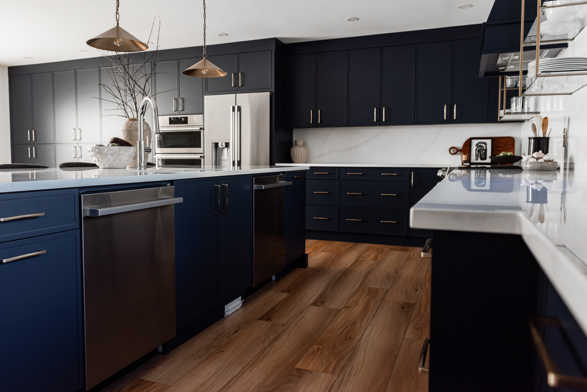 Bright renovated kitchen with large island, navy blue cabinetry, and warm wood accents in a family-focused home renovation
