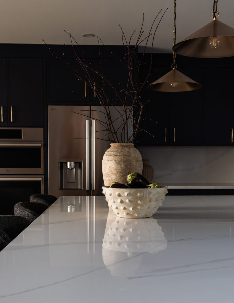 Bright renovated kitchen with large island, navy blue cabinetry, and warm wood accents in a family-focused home renovation