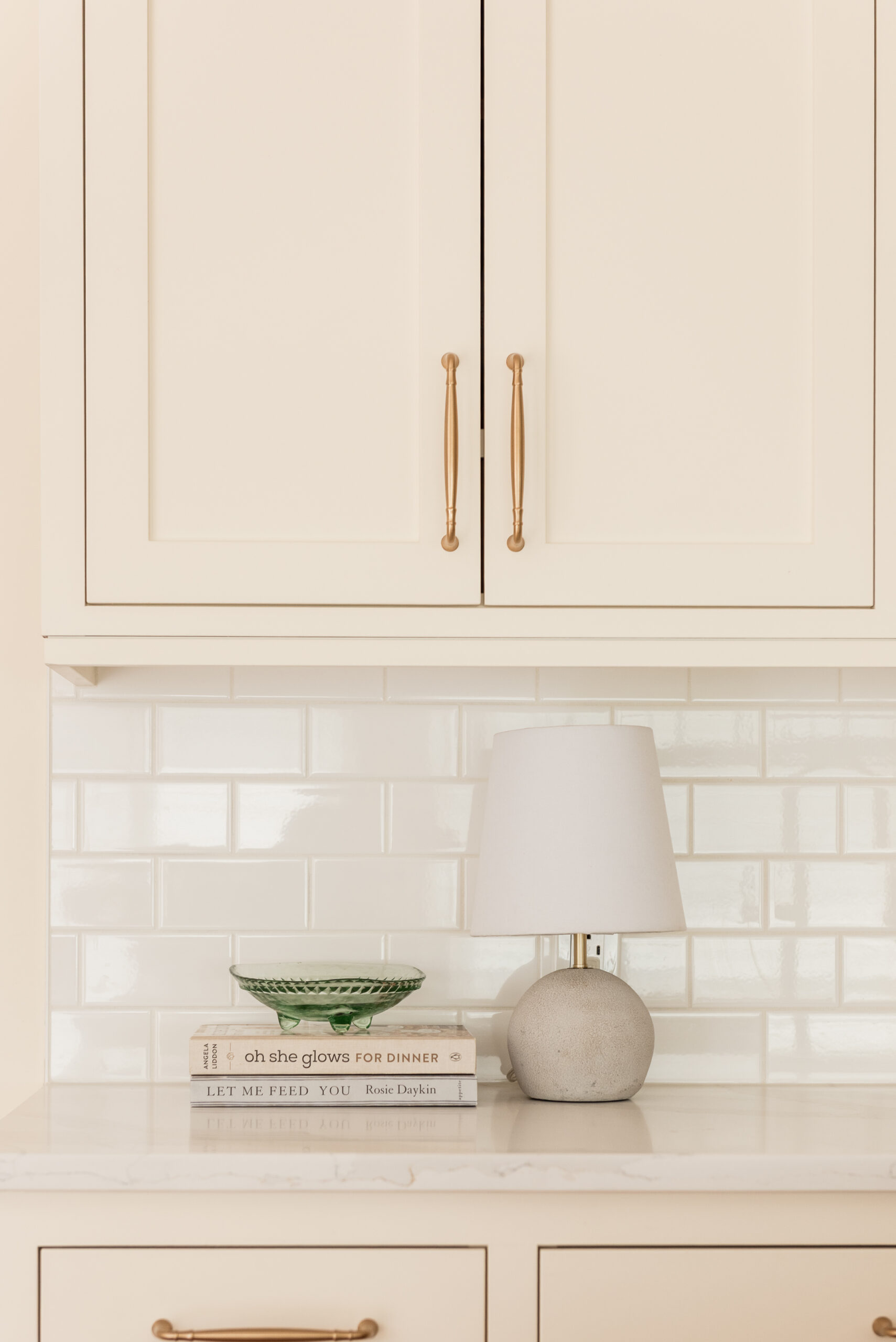 Timeless kitchen renovation combining restored inset cabinetry, warm maple hardwood floors, cream cabinetry, and durable quartz countertops.