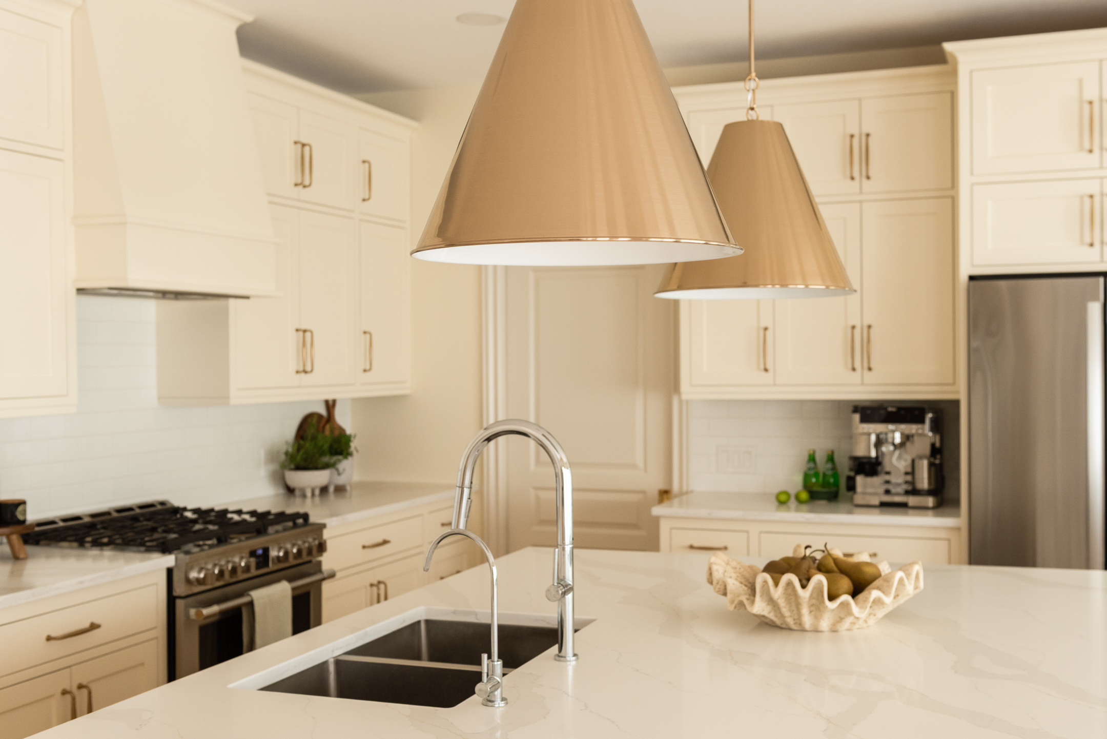 Traditional kitchen design with cream-painted cabinetry and warm wood floors carefully balanced to complement existing architectural character.