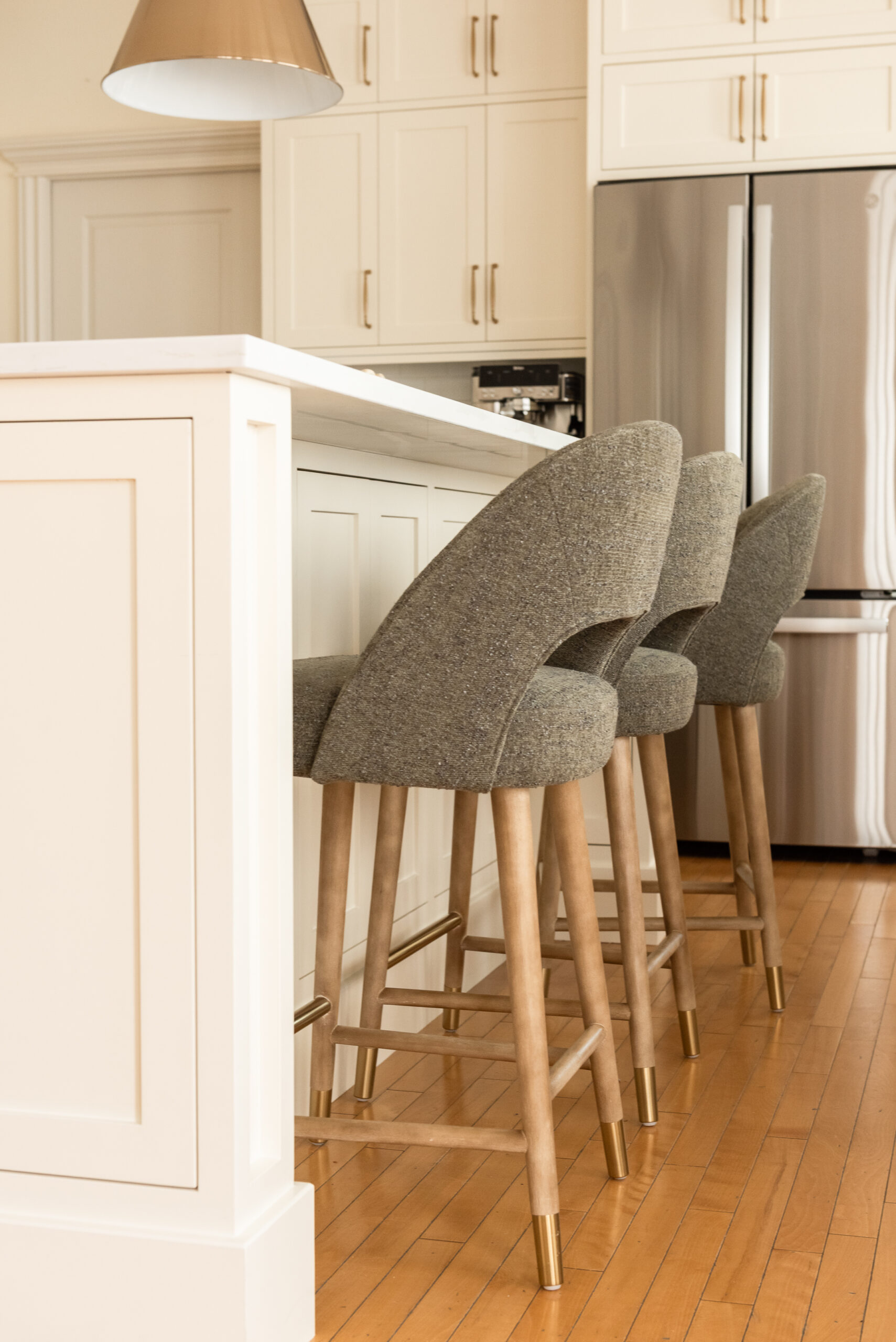 Traditional kitchen design with cream-painted cabinetry and warm wood floors carefully balanced to complement existing architectural character.