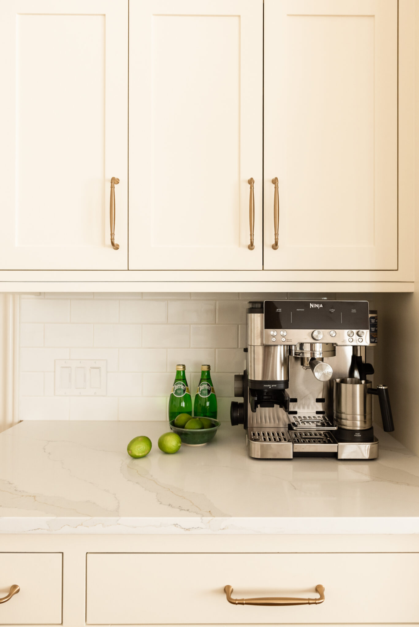Timeless kitchen renovation combining restored inset cabinetry, warm maple hardwood floors, cream cabinetry, and durable quartz countertops.
