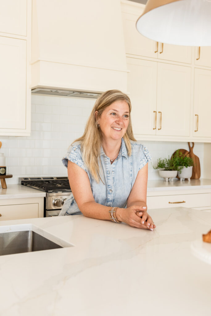 Large custom kitchen island designed for family living in a renovated cream kitchen with inset cabinetry, quartz countertops, and warm maple hardwood floors.