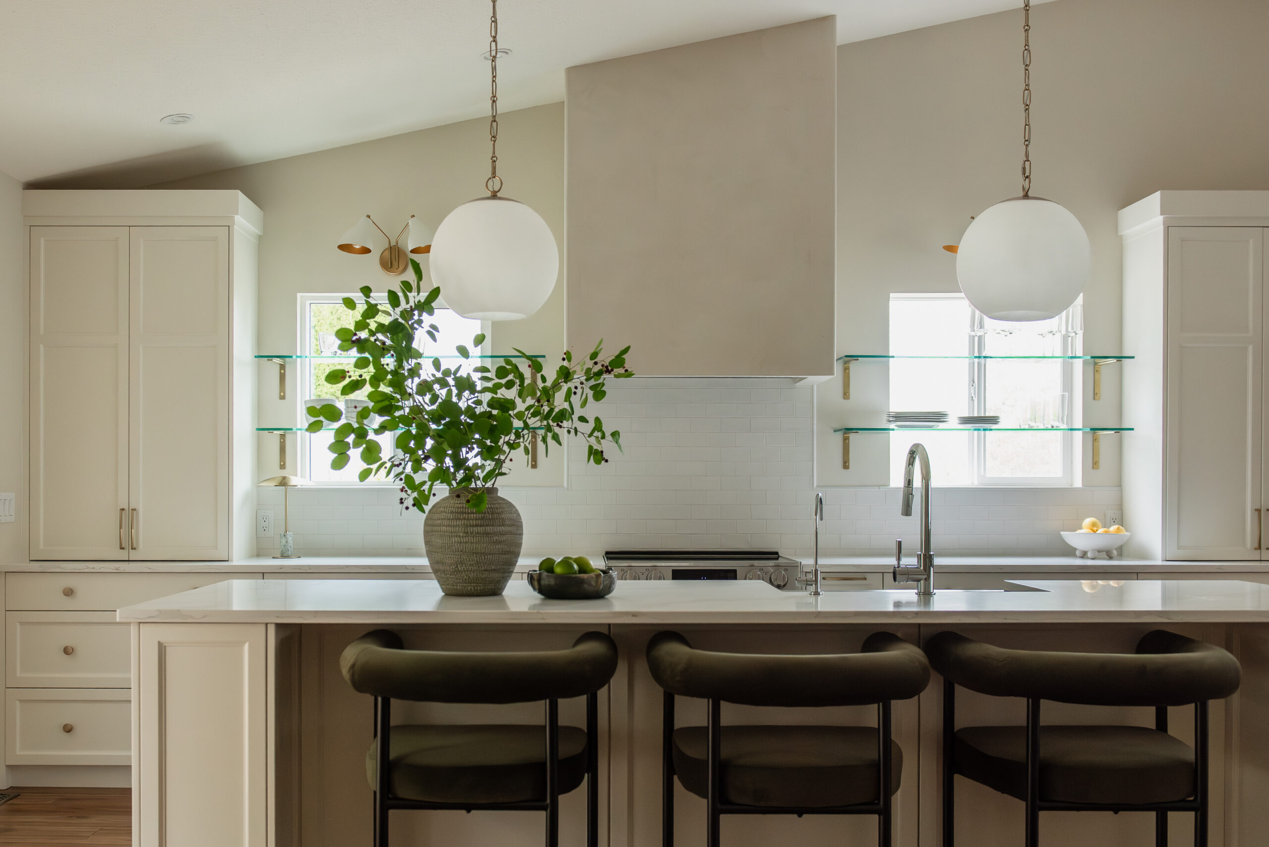 Kelowna kitchen renovation with glass shelves over windows and statement plaster hood