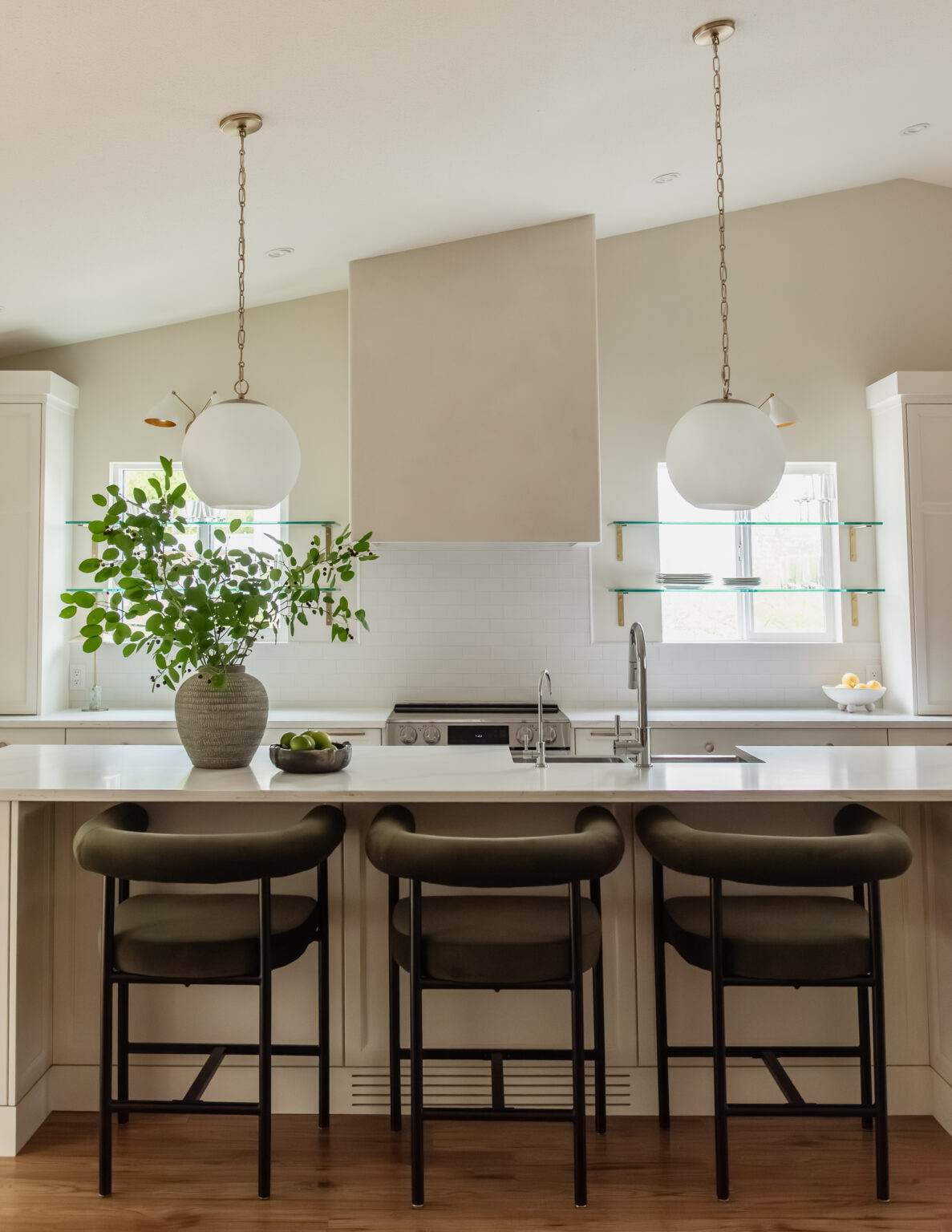 Kelowna kitchen renovation with glass shelves over windows and statement plaster hood