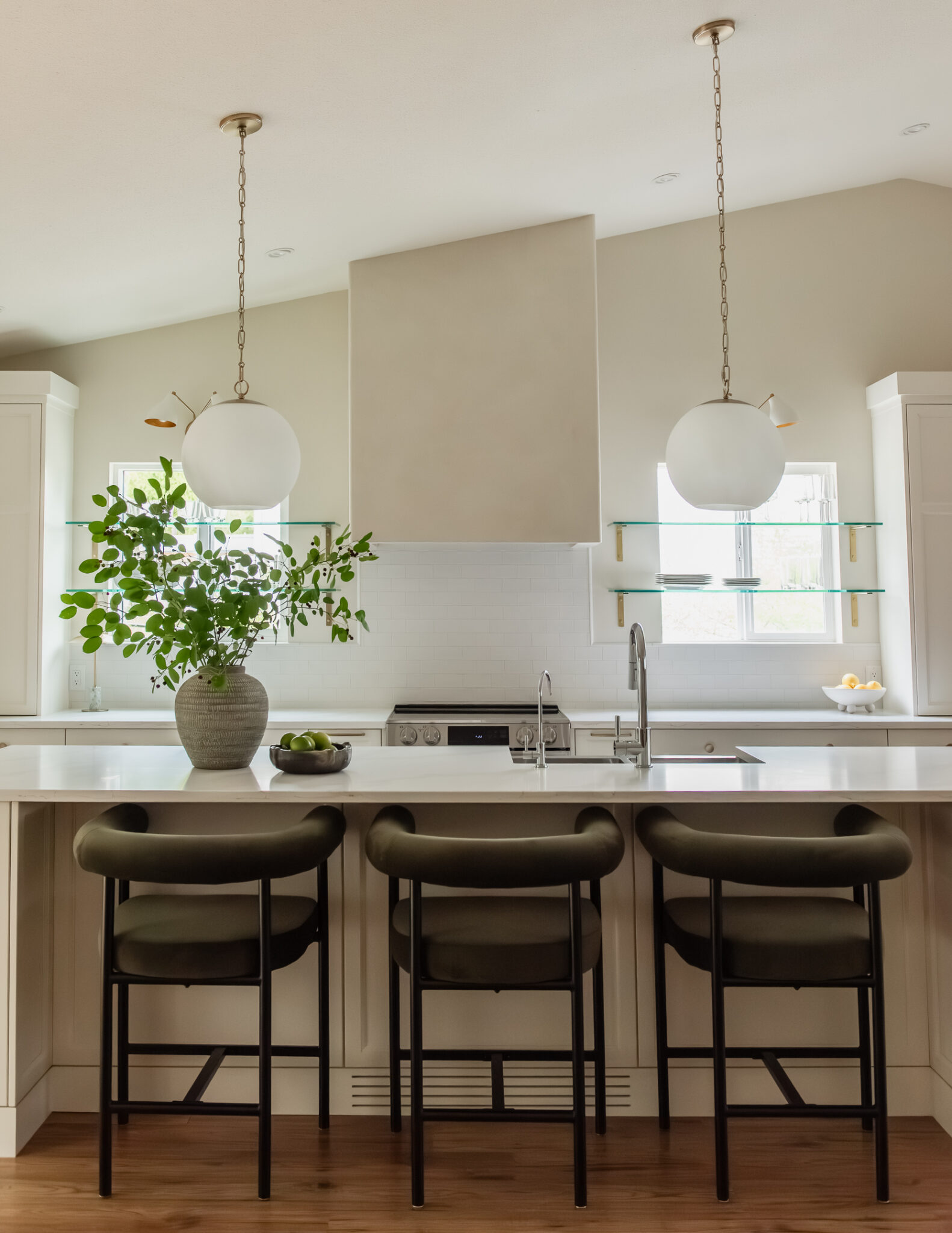 Kelowna kitchen renovation with glass shelves over windows and statement plaster hood