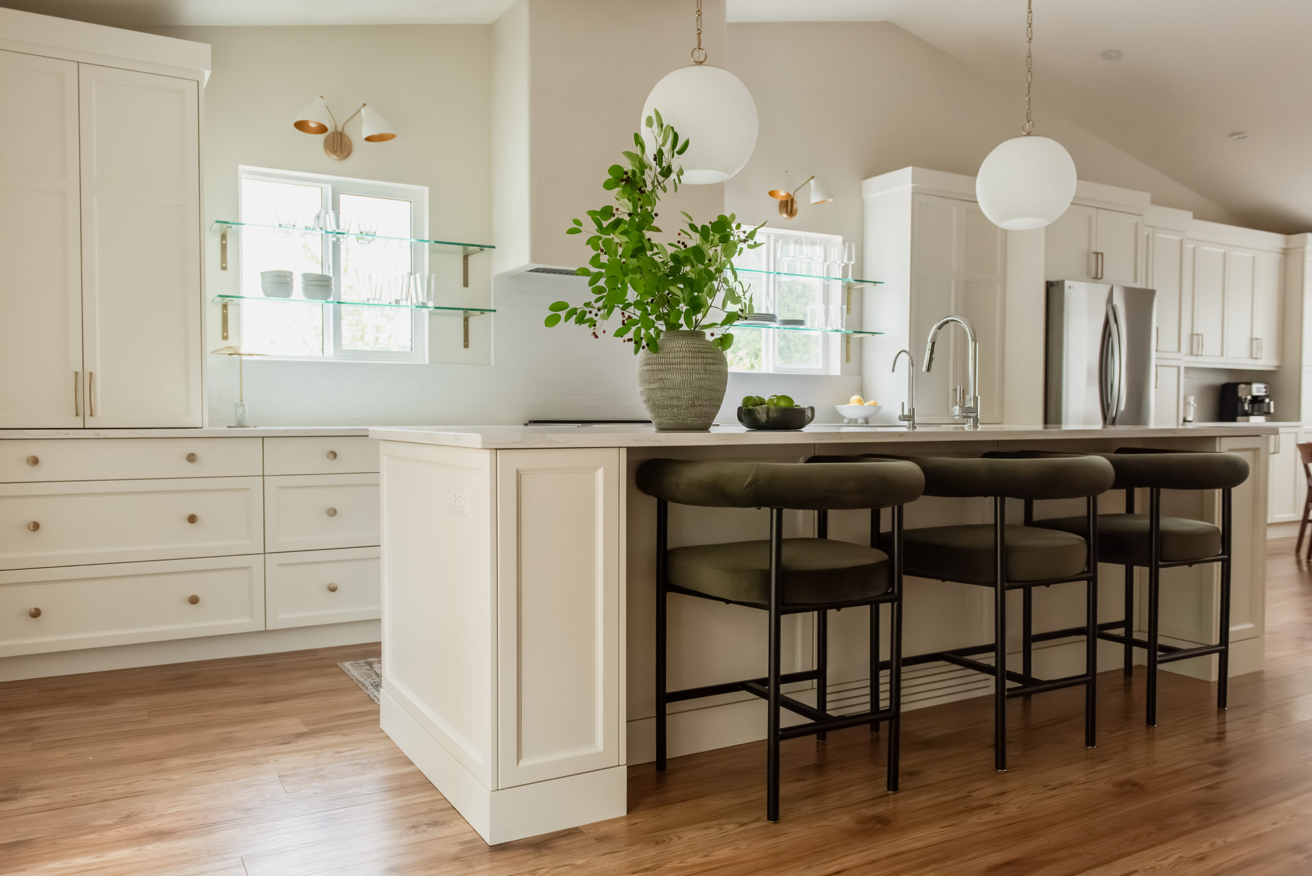 Kelowna kitchen renovation with glass shelves over windows and statement plaster hood