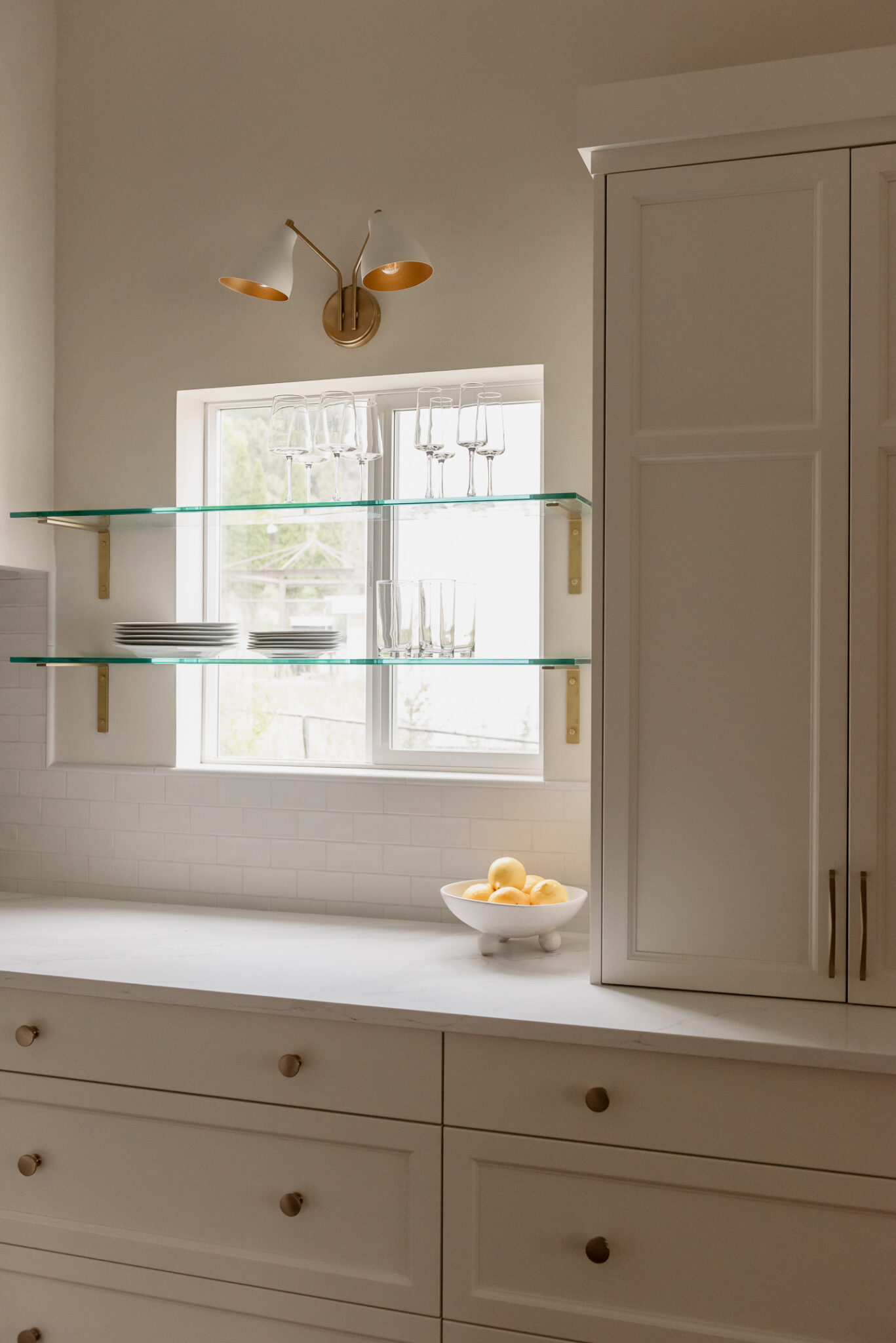 Kelowna kitchen renovation with glass shelves over windows and statement plaster hood