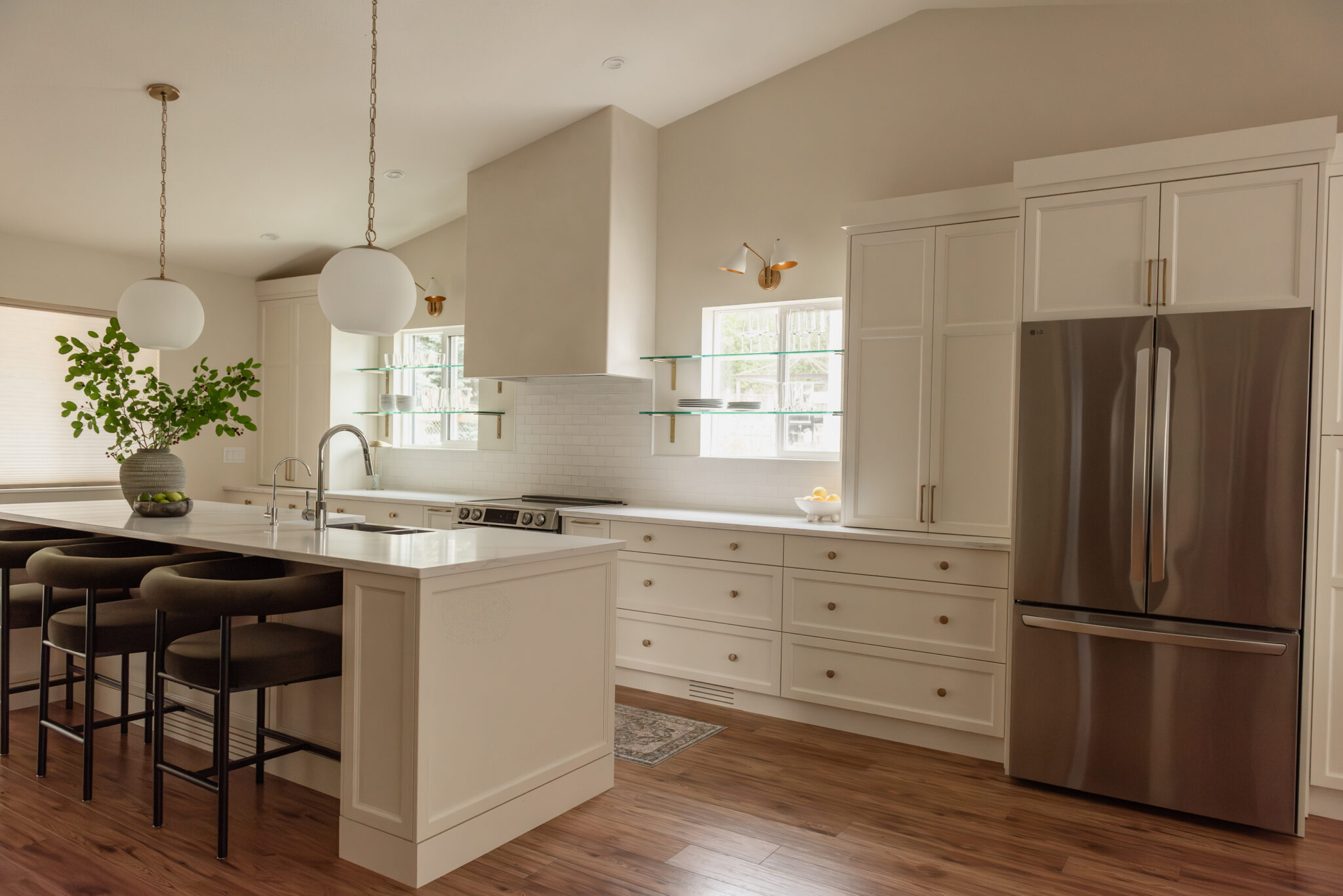 Kelowna kitchen renovation with glass shelves over windows and statement plaster hood