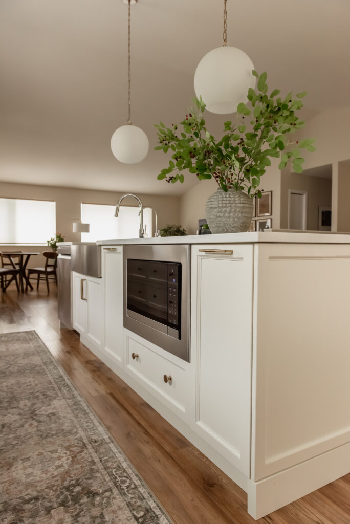 Large kitchen island with olive green stools and globe pendant lights