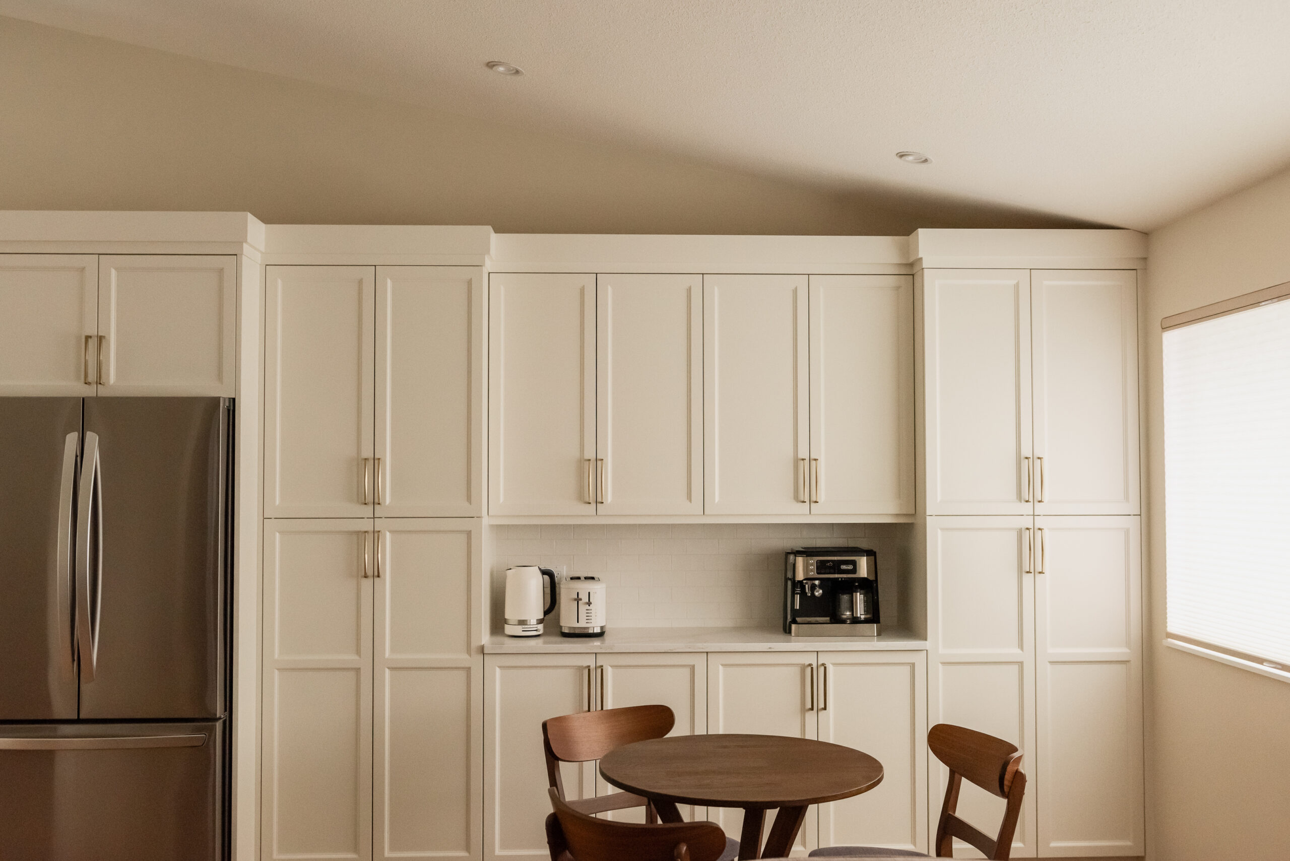 Custom kitchen coffee bar with floor-to-ceiling pantry cabinetry