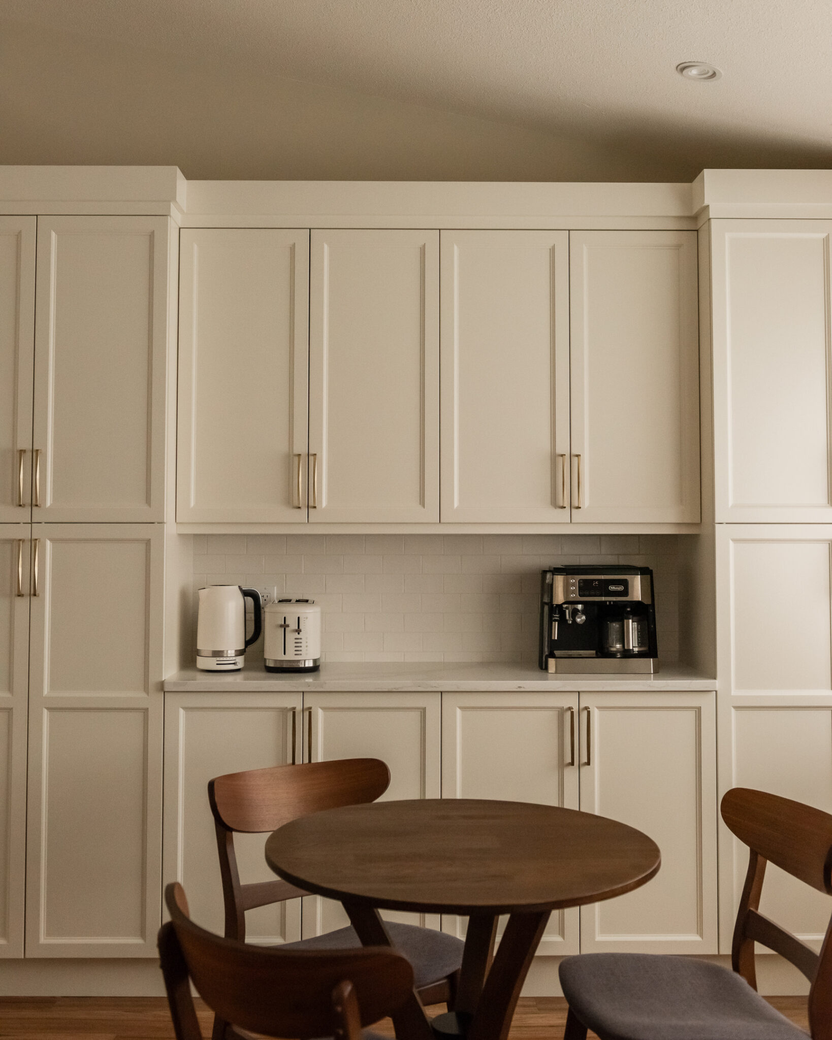 Custom kitchen coffee bar with floor-to-ceiling pantry cabinetry