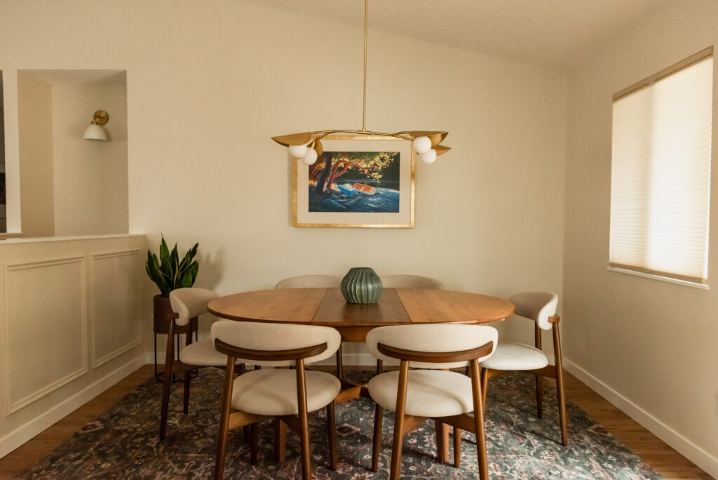 Open concept kitchen and dining room renovation with warm wood floors and white cabinetry