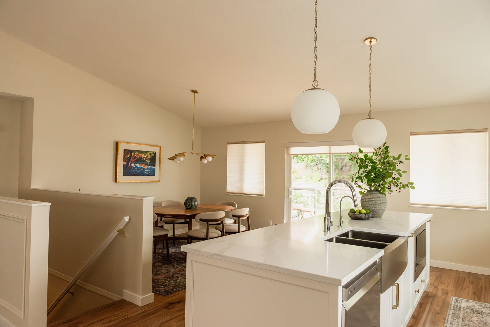 Open concept kitchen and dining room renovation with warm wood floors and white cabinetry