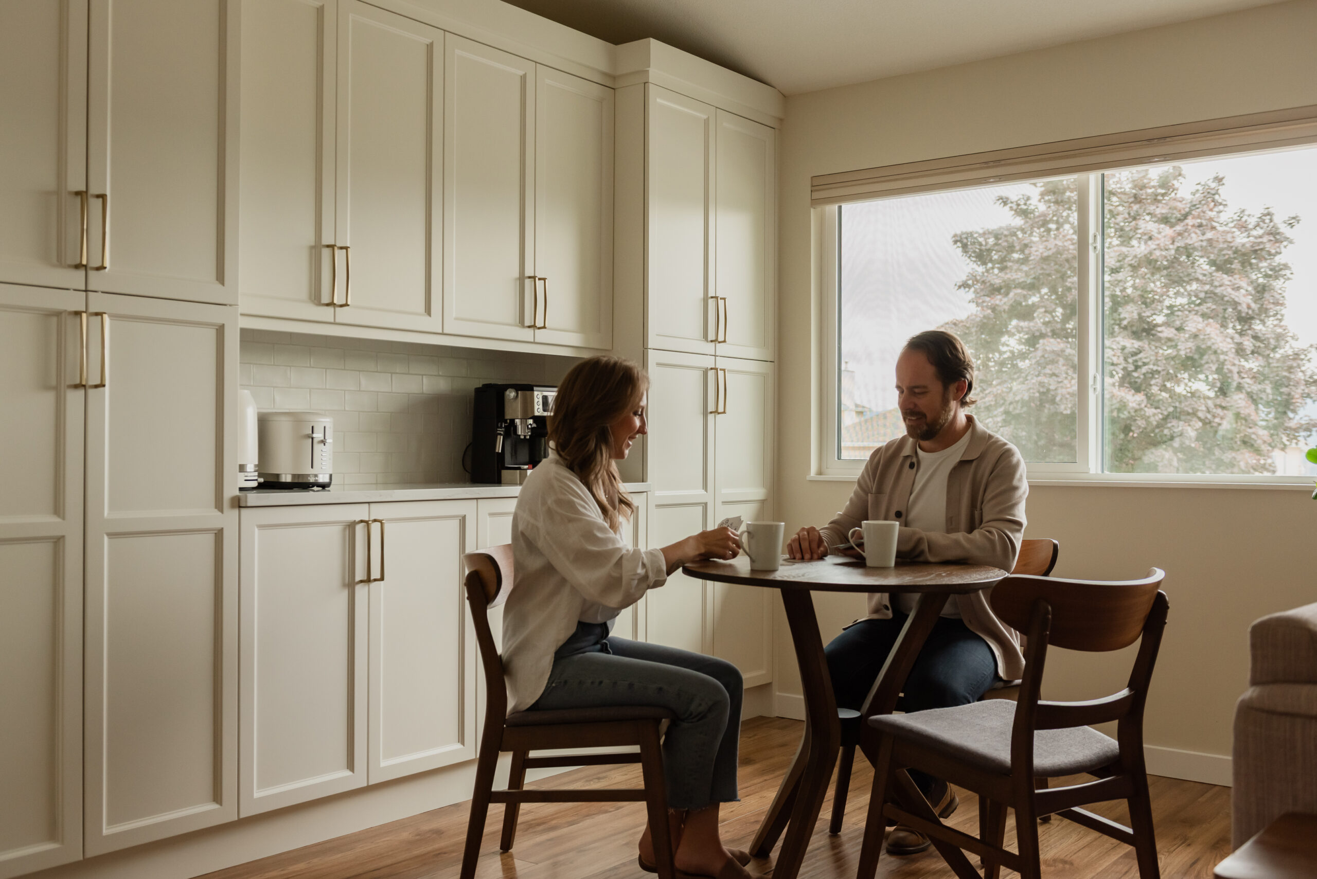 Couple enjoying coffee in a custom kitchen coffee bar with floor-to-ceiling pantry cabinetry