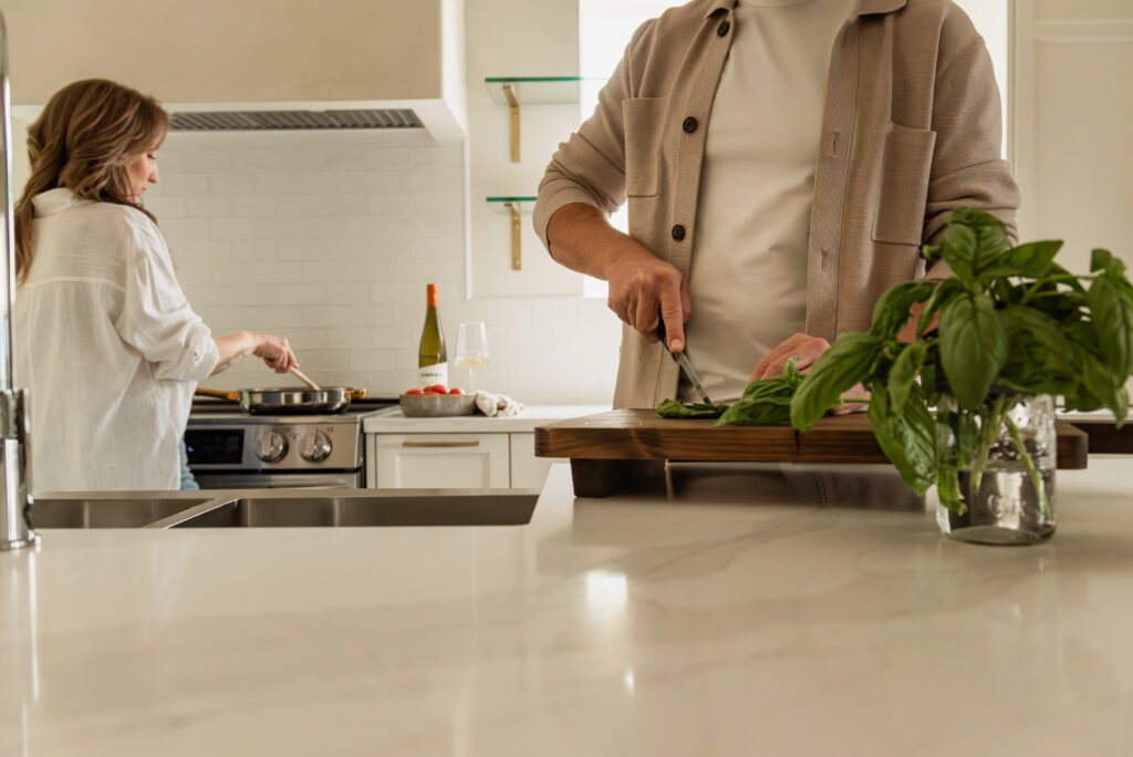Couple cooking together in a bright open concept white kitchen renovation