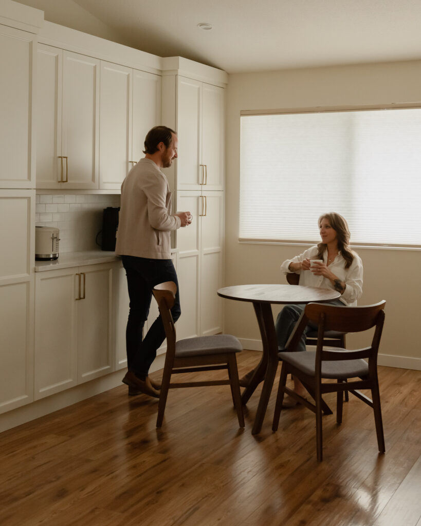 Couple enjoying coffee in a custom kitchen coffee bar with floor-to-ceiling pantry cabinetry