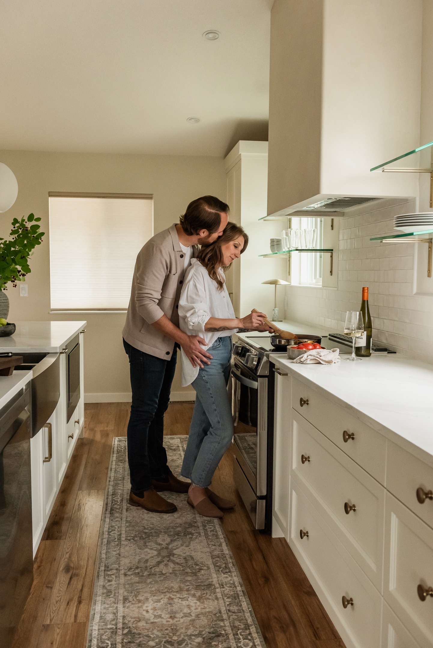 Couple cooking together in a bright open concept white kitchen renovation