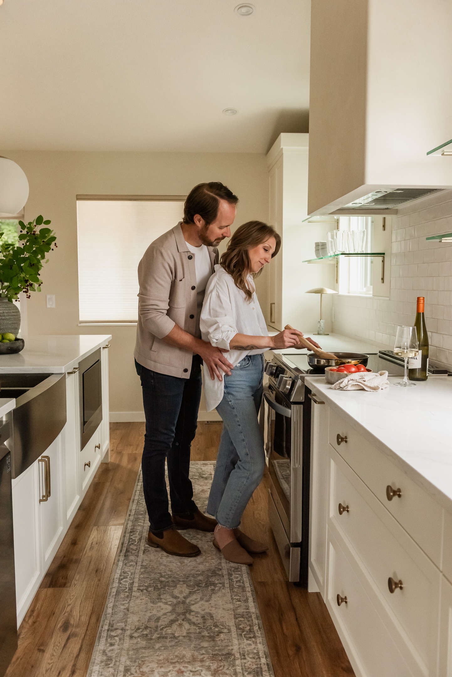 Couple cooking together in a bright open concept white kitchen renovation