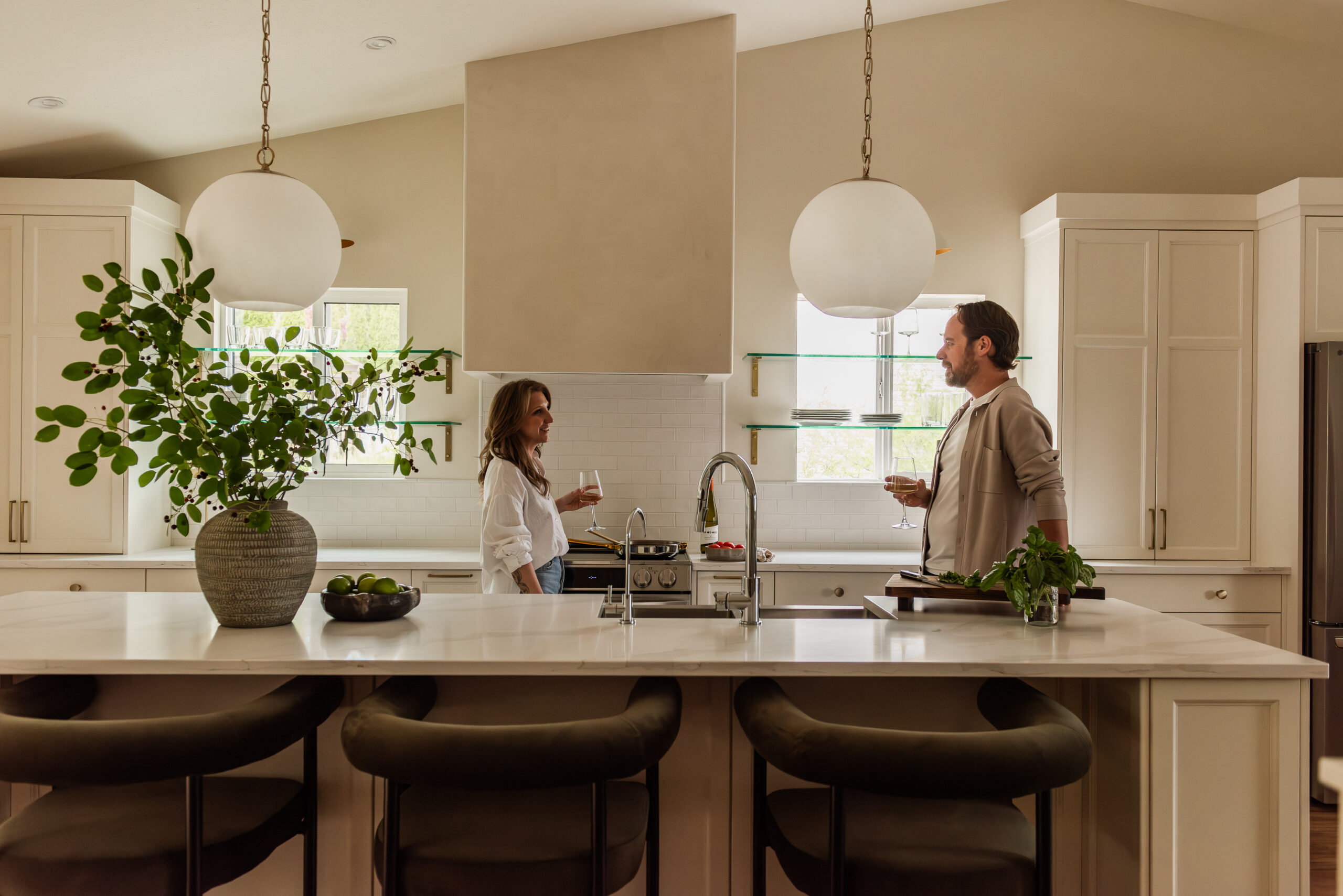 Couple cooking together in a bright open concept white kitchen renovation