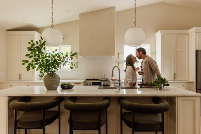 Couple cooking together in a bright open concept white kitchen renovation