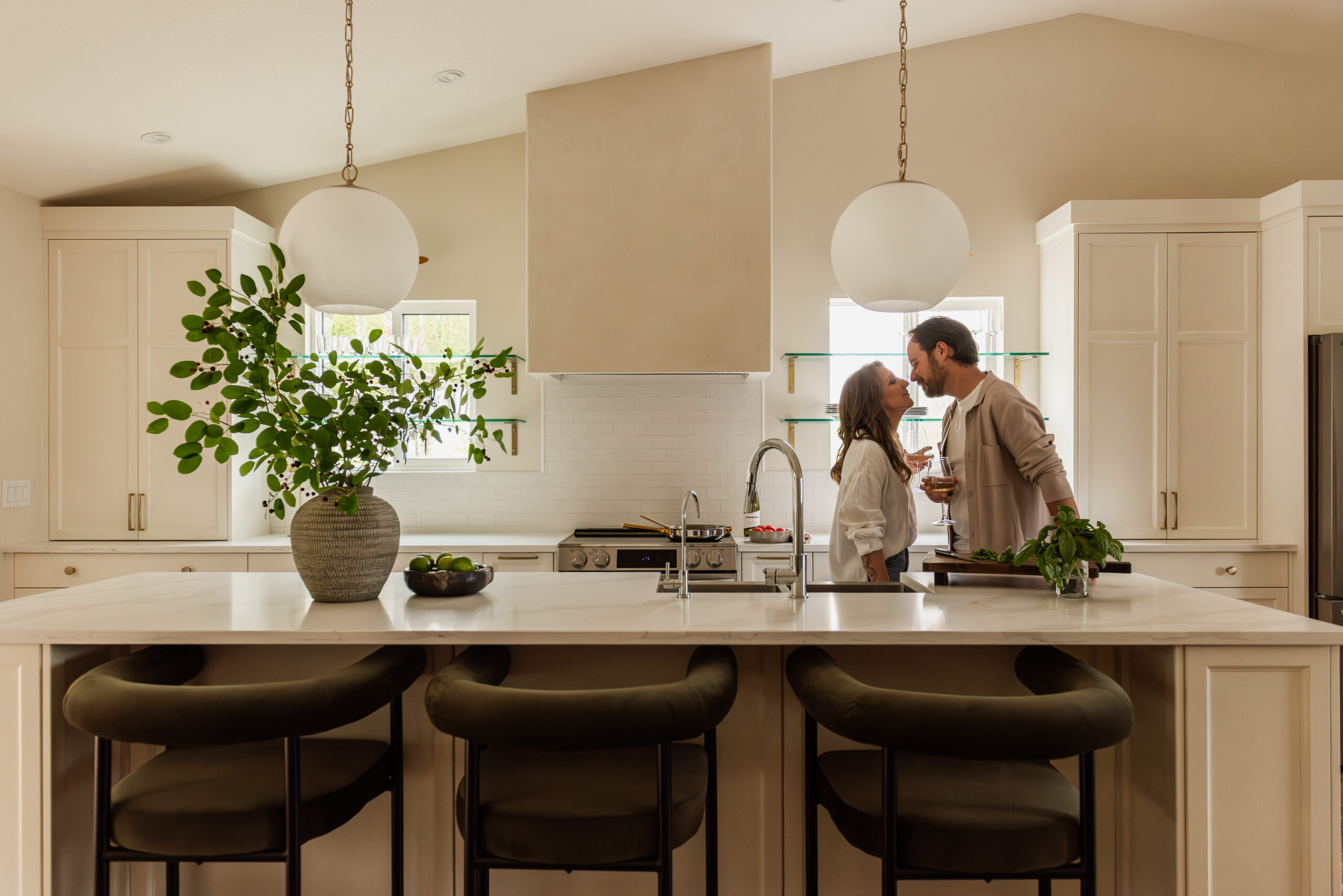 Couple cooking together in a bright open concept white kitchen renovation