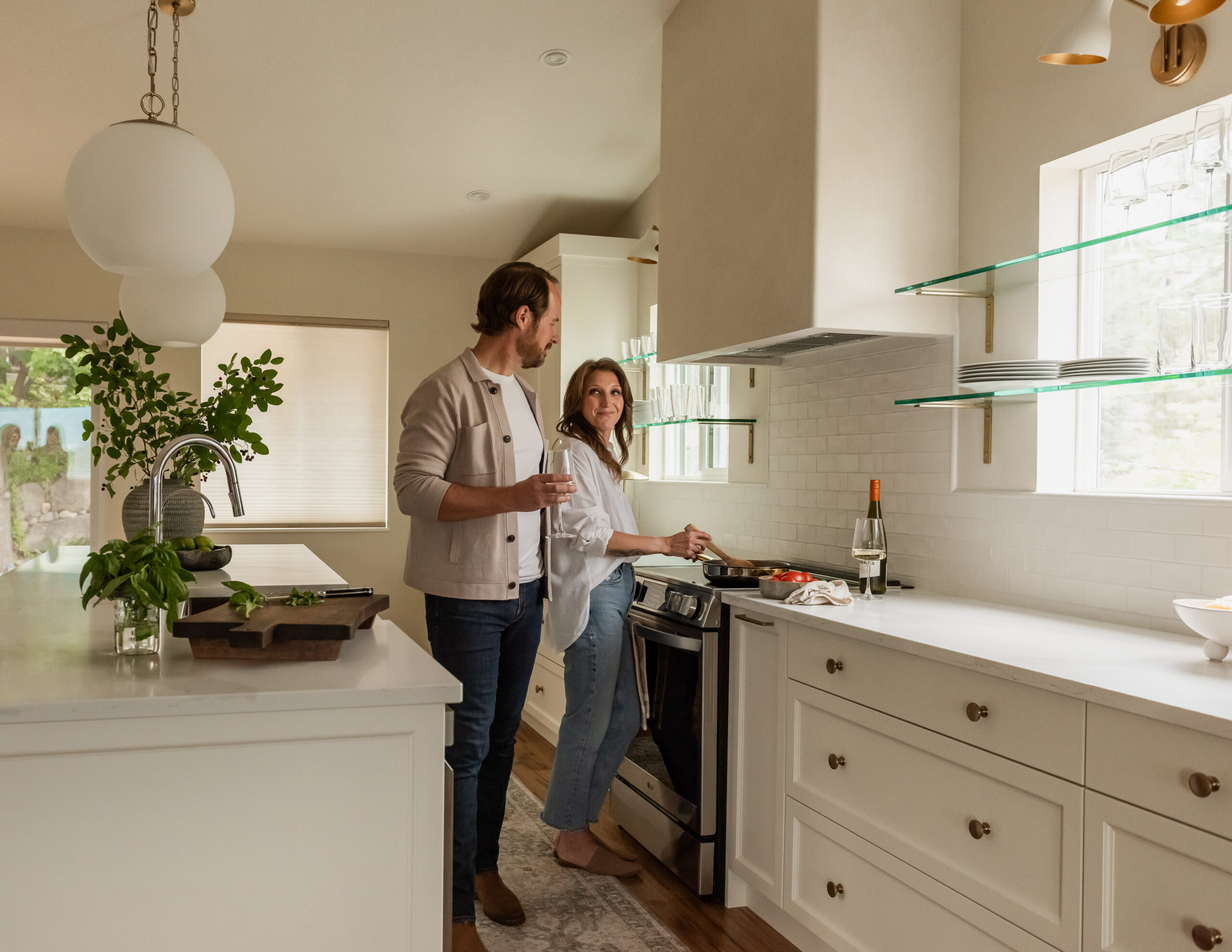 Couple enjoying wine in a custom kitchen with oversized island and plaster range hood
