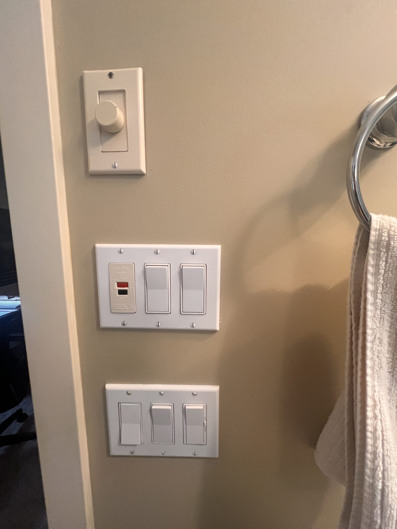 Before - an abundance of unattractive electrical switches added visual clutter to this bathroom