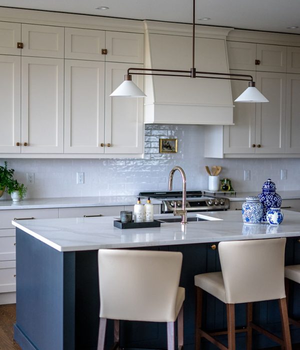 Transitional cream kitchen with navy island, modern island light
