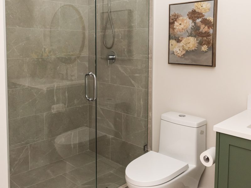 basement bathroom with green vanity and walk in shower