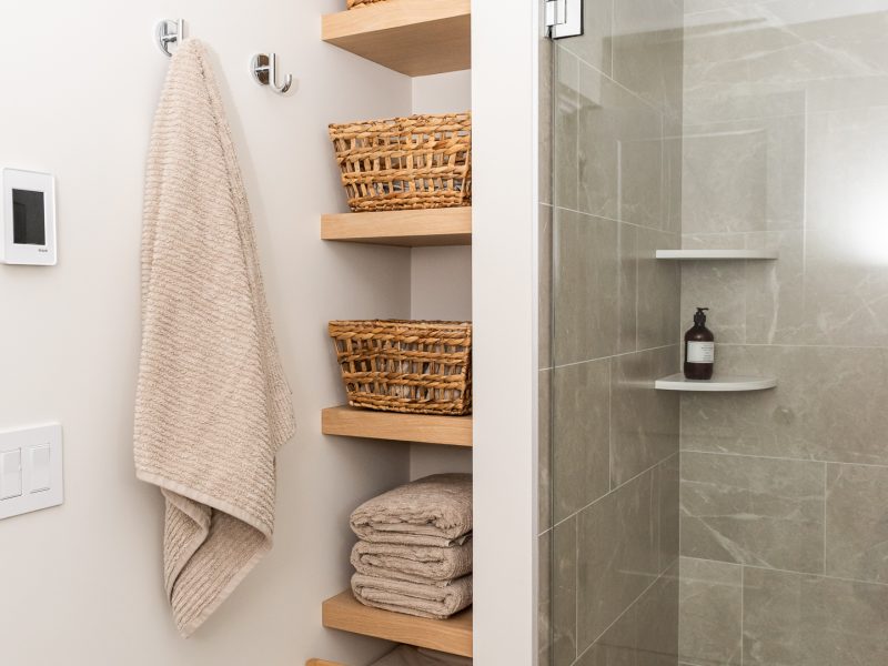 basement bathroom with open shelving and walk in shower