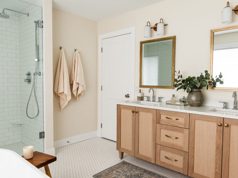 transitional ensuite with white oak vanity, vintage mirrors and styling