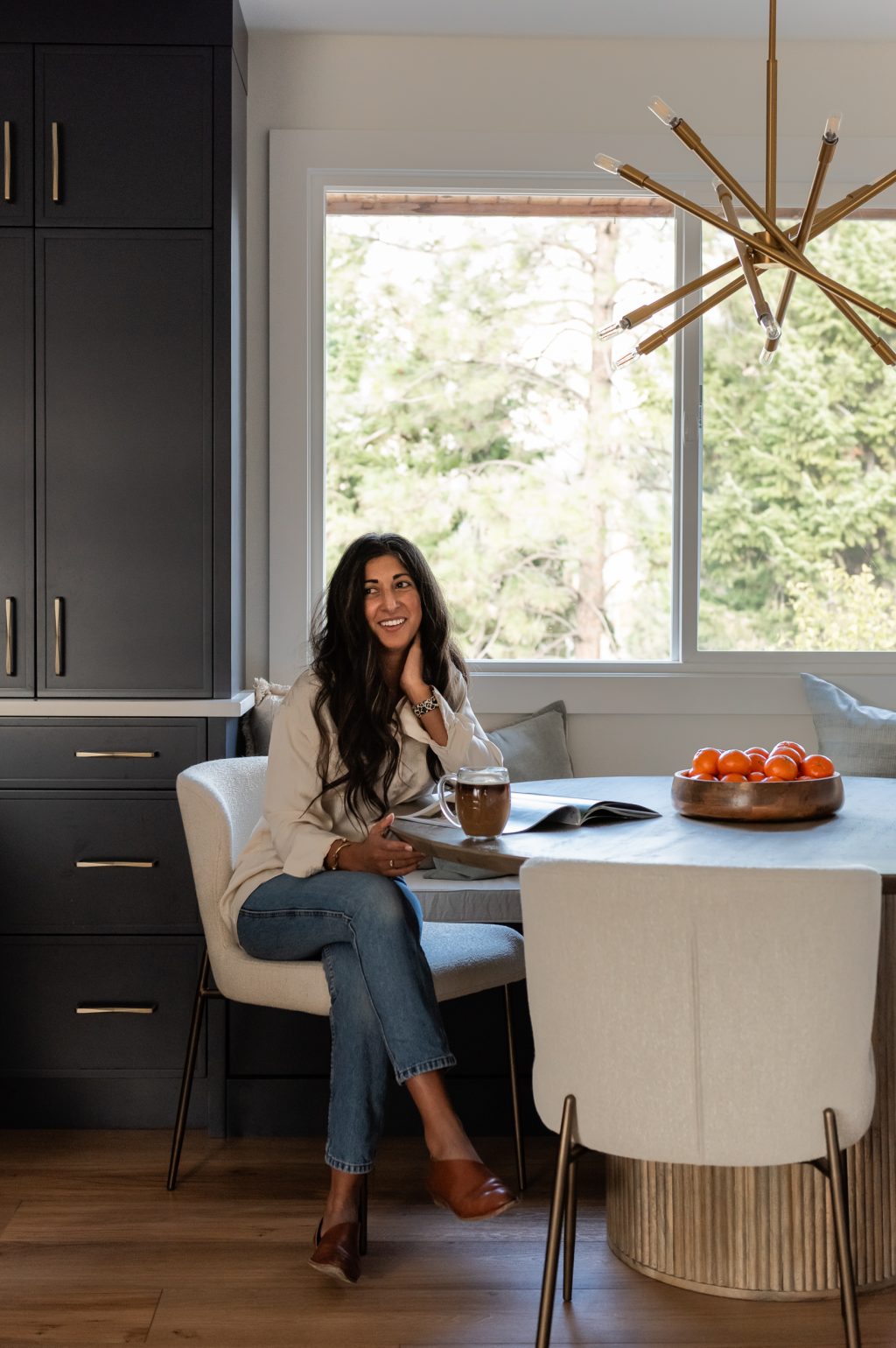 Women in bright renovated kitchen with large island, navy blue cabinetry, and warm wood accents in a family-focused home renovation