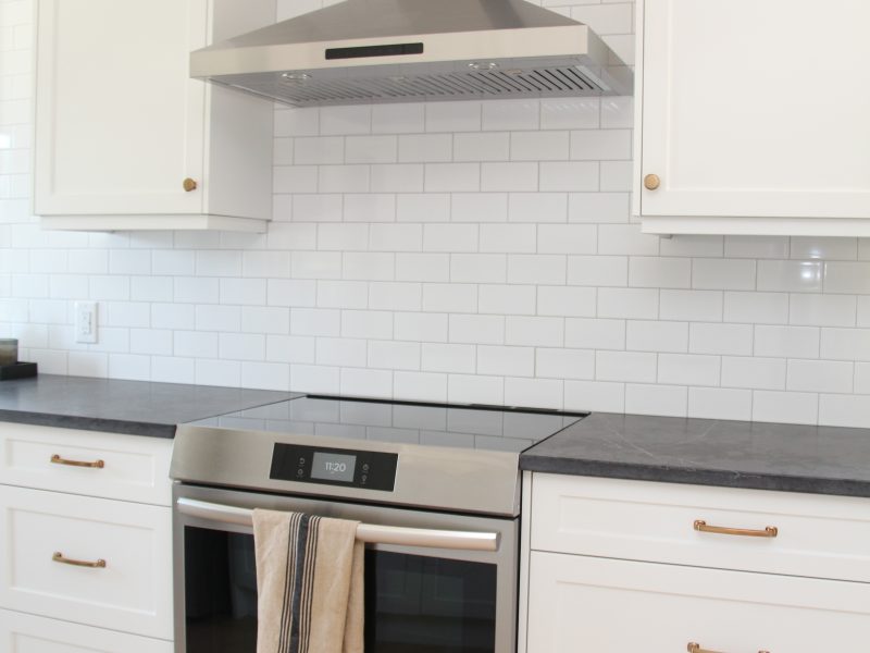 subway tile to ceiling, chimney hood fan, classic white kitchen cabinets, timeless white kitchen