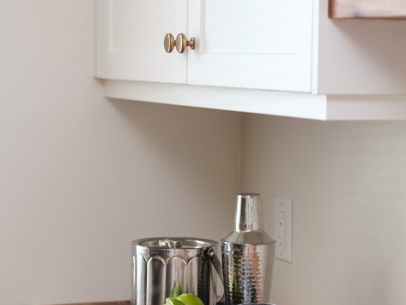 bar in dining room, white cabinets, butcher block countertop, floating wood shelves