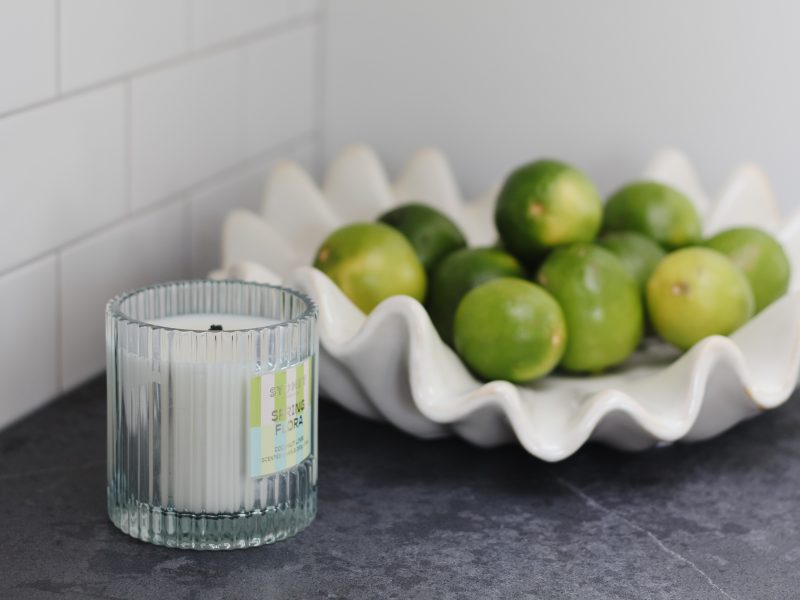 kitchen styling, bowl of limes, fluted candle, black quartz countertop, subway tile backsplash