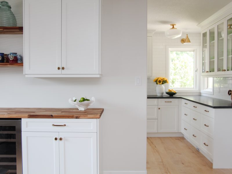 bar in dining room, white cabinets, butcher block countertop, floating wood shelves