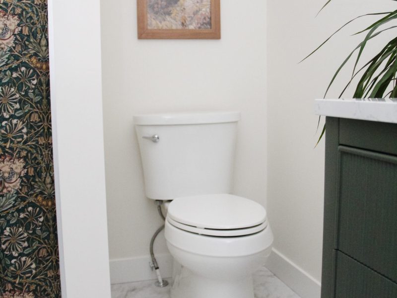 contemporary kids bathroom with green vanity and gold accents