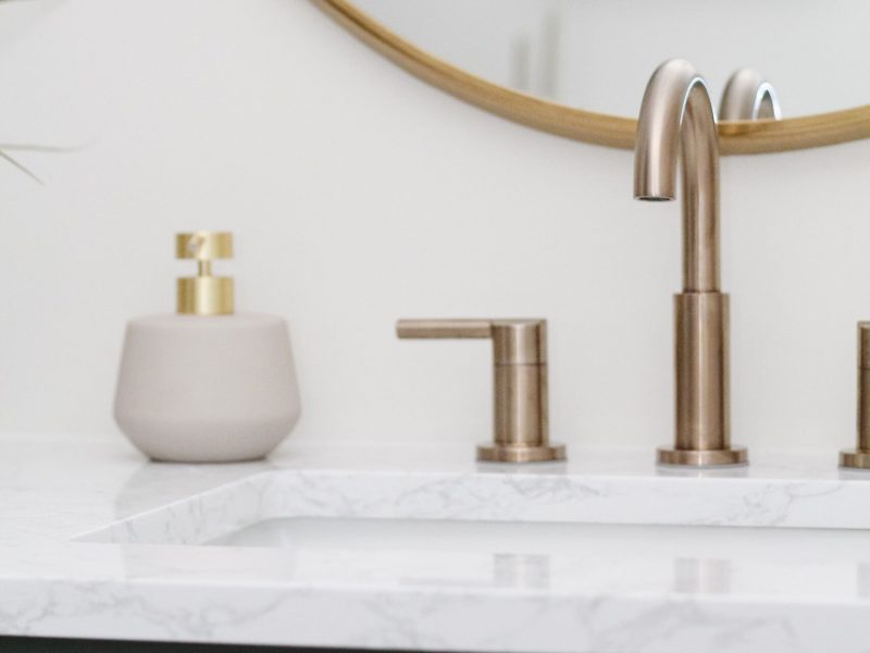 contemporary kids bathroom with green vanity and gold accents