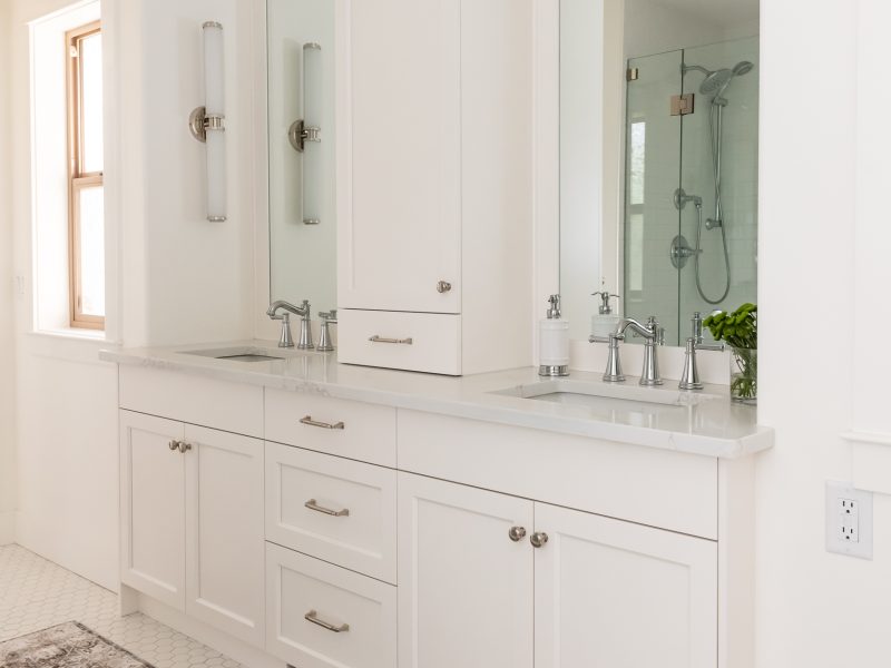 Traditional white vanity with linen tower and crown moulding