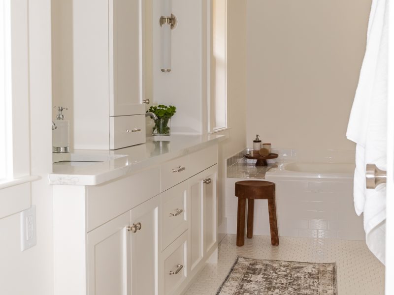 Traditional white vanity with linen tower and crown moulding