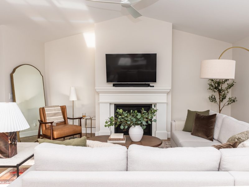 transitional living room cast stone fireplace, floor mirror