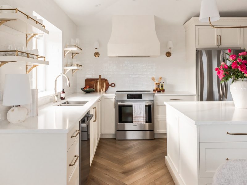 transitional cream kitchen, plaster hood, open brass shelves, tile to ceiling, herringbone floor