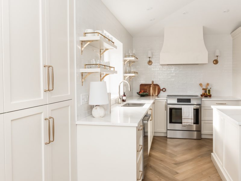 transitional cream kitchen, plaster hood, open brass shelves, tile to ceiling