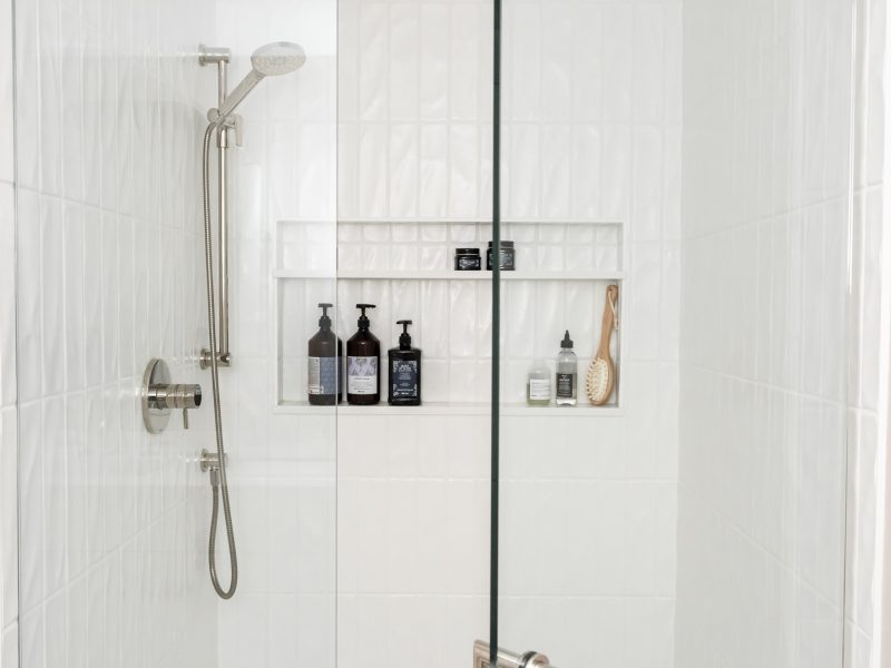 vertical textured subway tile shower, shower niche, glass shower enclosure