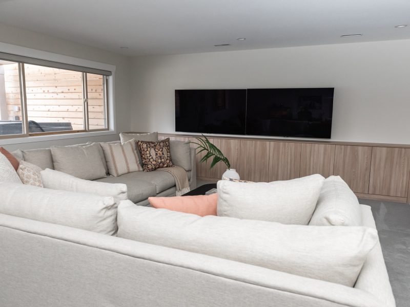 basement games room, sectional and coffee table styled, two TVs